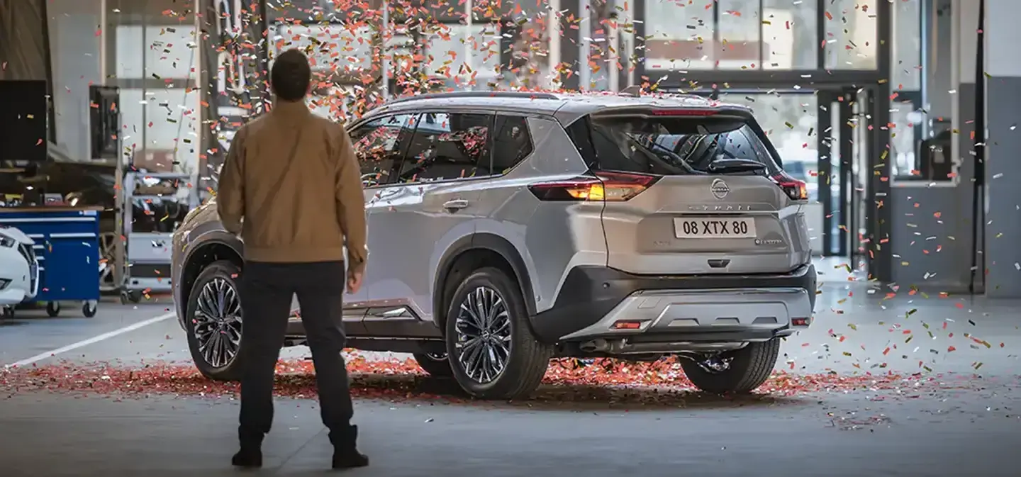 Nissan X-Trail dans un atelier Nissan sous une pluie de confettis